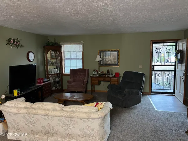 a living room with furniture a flat screen tv and a window