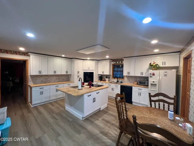 a kitchen with a table chairs refrigerator and cabinets