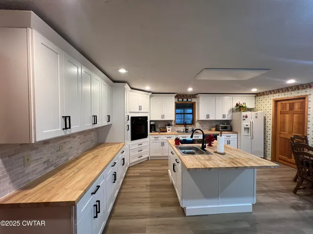 a large kitchen with stainless steel appliances lots of counter space and a sink
