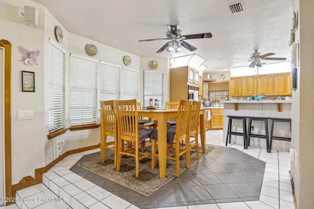 a dining hall with stainless steel appliances a dining table and chairs with wooden floor