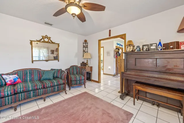 a living room with furniture a baby crib and a window