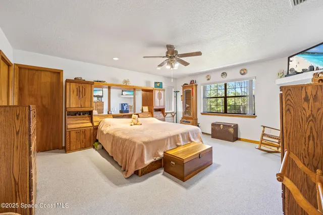 a spacious bedroom with a bed and a flat screen television