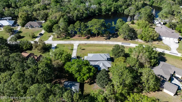 an aerial view of a house with a yard and lake view