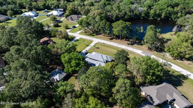 an aerial view of a house with a yard and lake view