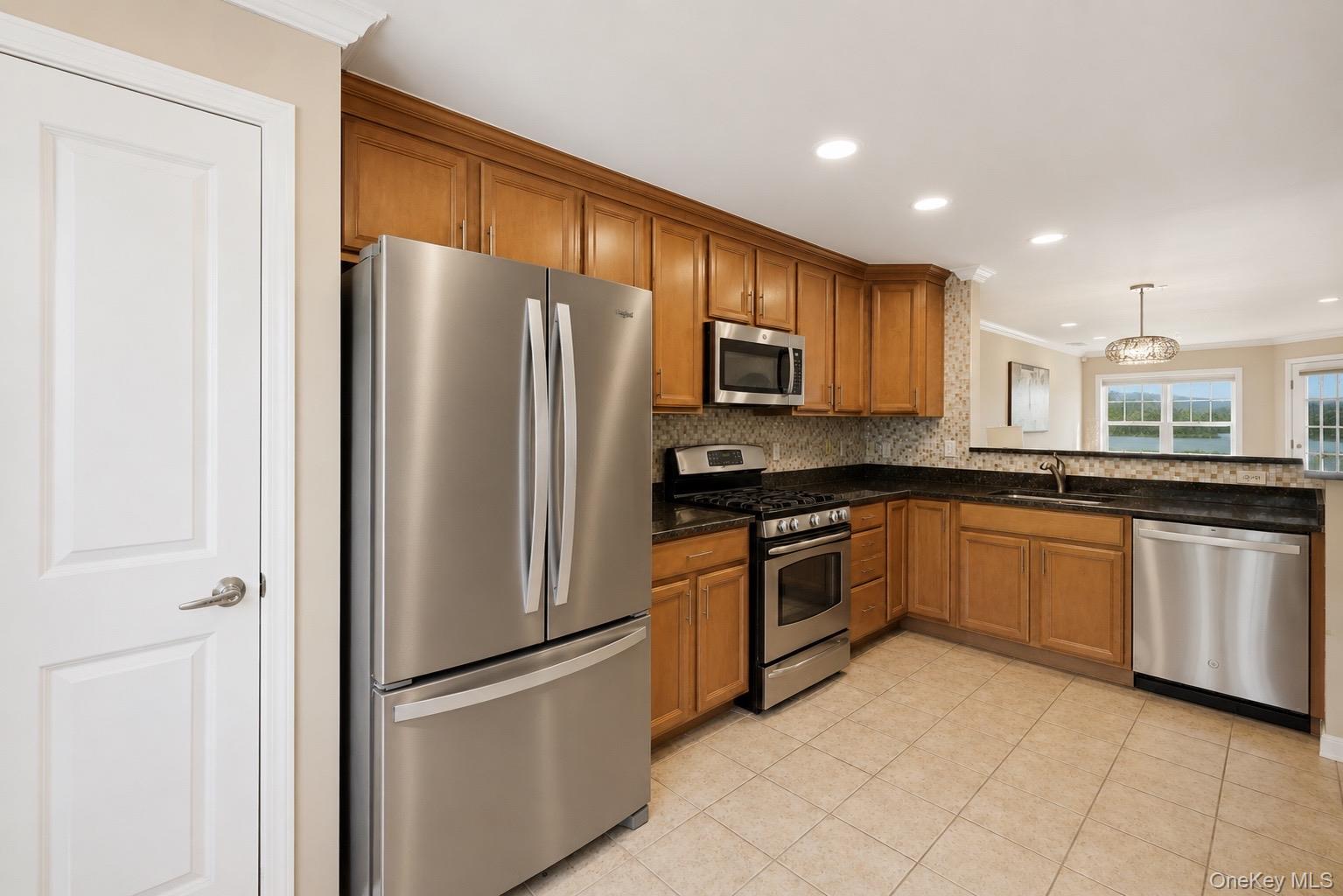 323 Waterside Close Peekskill, NY 10566 - Photo 11 of 42 Kitchen featuring new recessed lights, wood cabinetry, stainless steel appliances, granite countertops, and a new mosaic tile backsplash