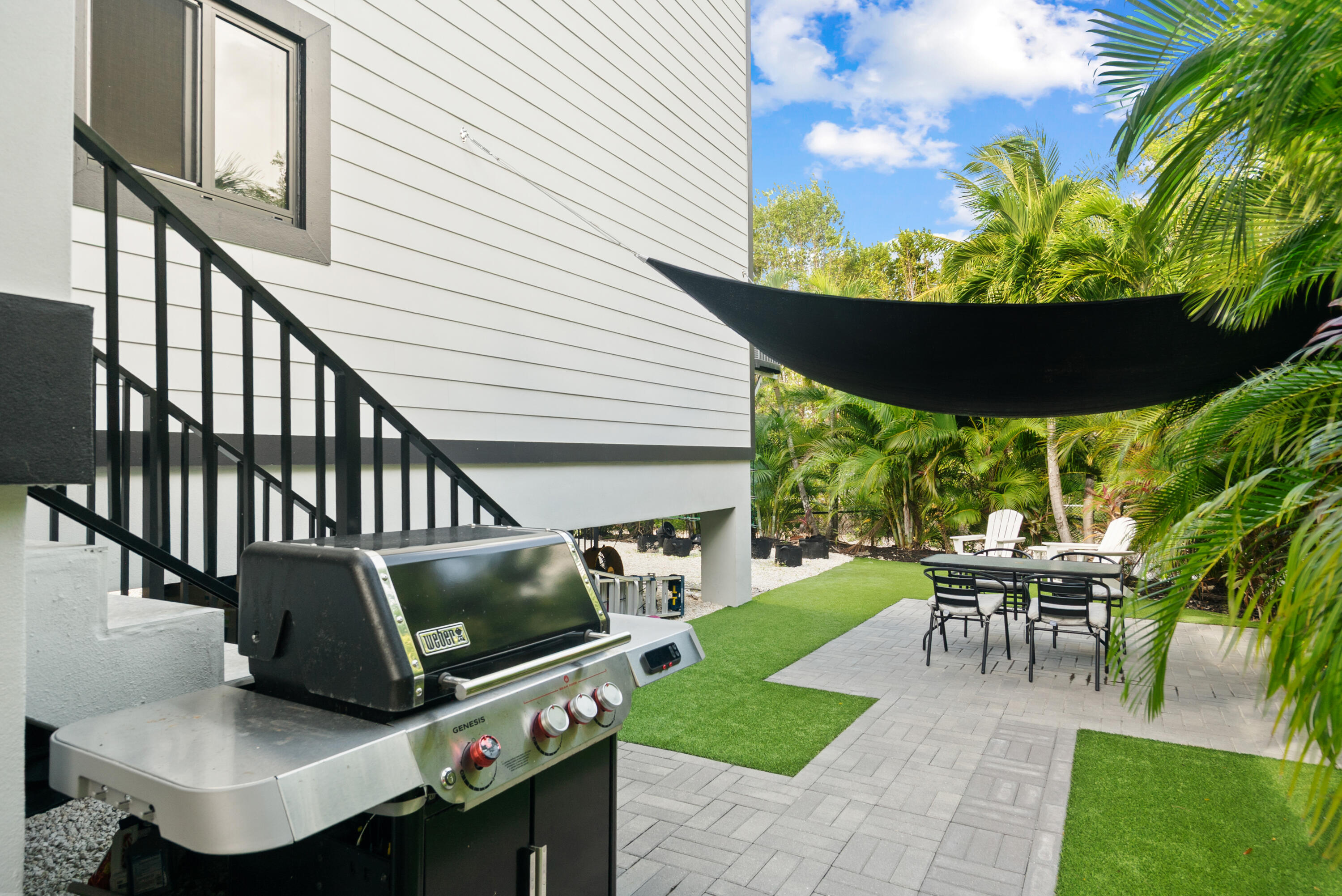 13 Coral Way Key Largo, FL 33037 - Photo 21 of 34 a view of a patio with table and chairs potted plants and a palm tree