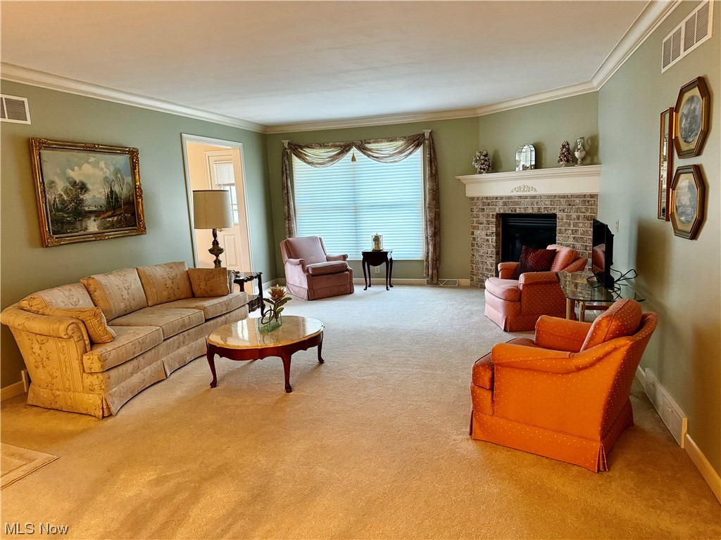 183 Mathews Road, Unit A Youngstown, OH 44512 - Photo 14 of 32 Carpeted living room featuring ornamental molding and a brick fireplace
