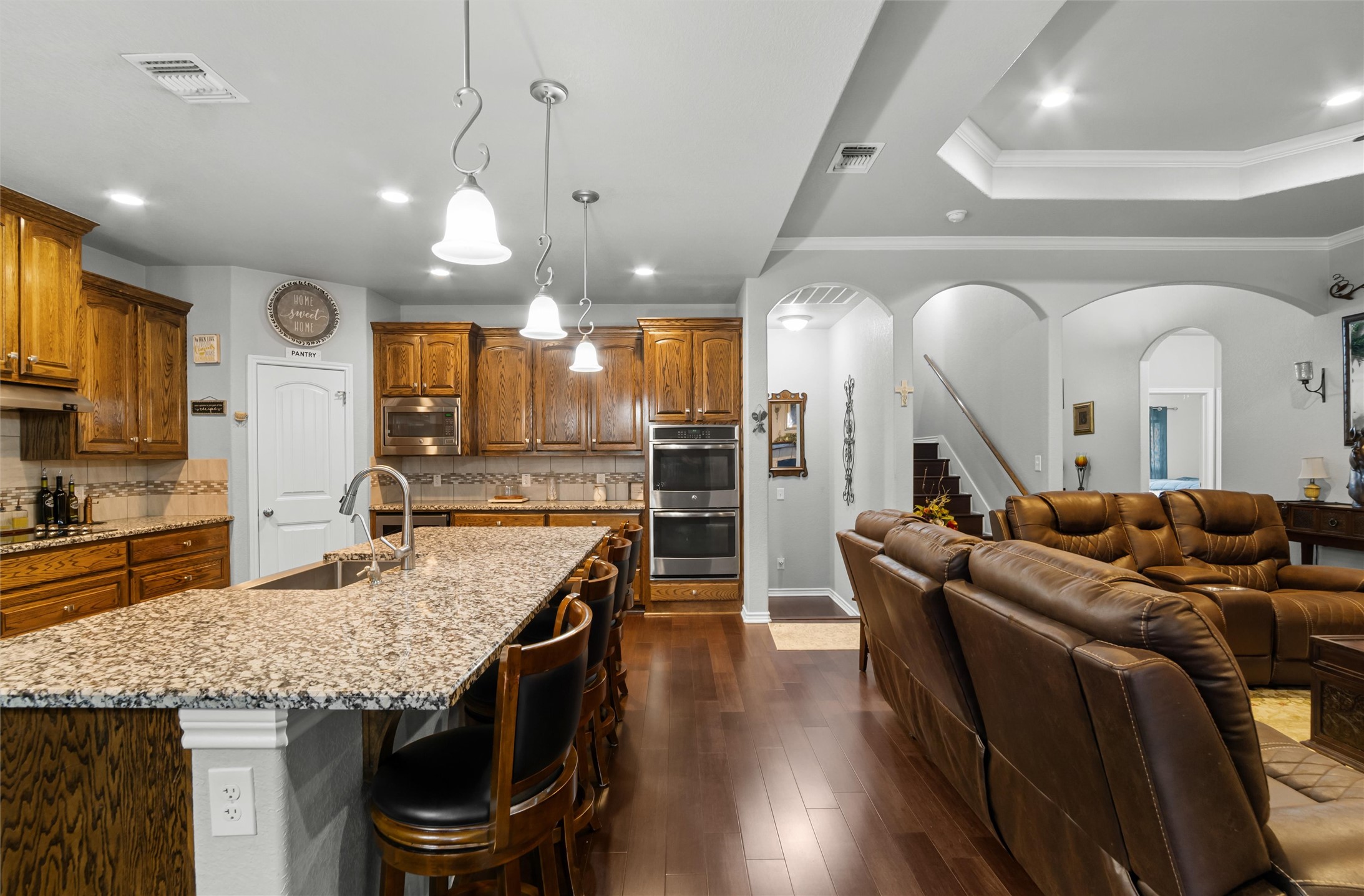 16017 Toby Court Temple, TX 76502 - Photo 7 of 33 a large kitchen with stainless steel appliances kitchen island granite countertop a table chairs in it and wooden floors