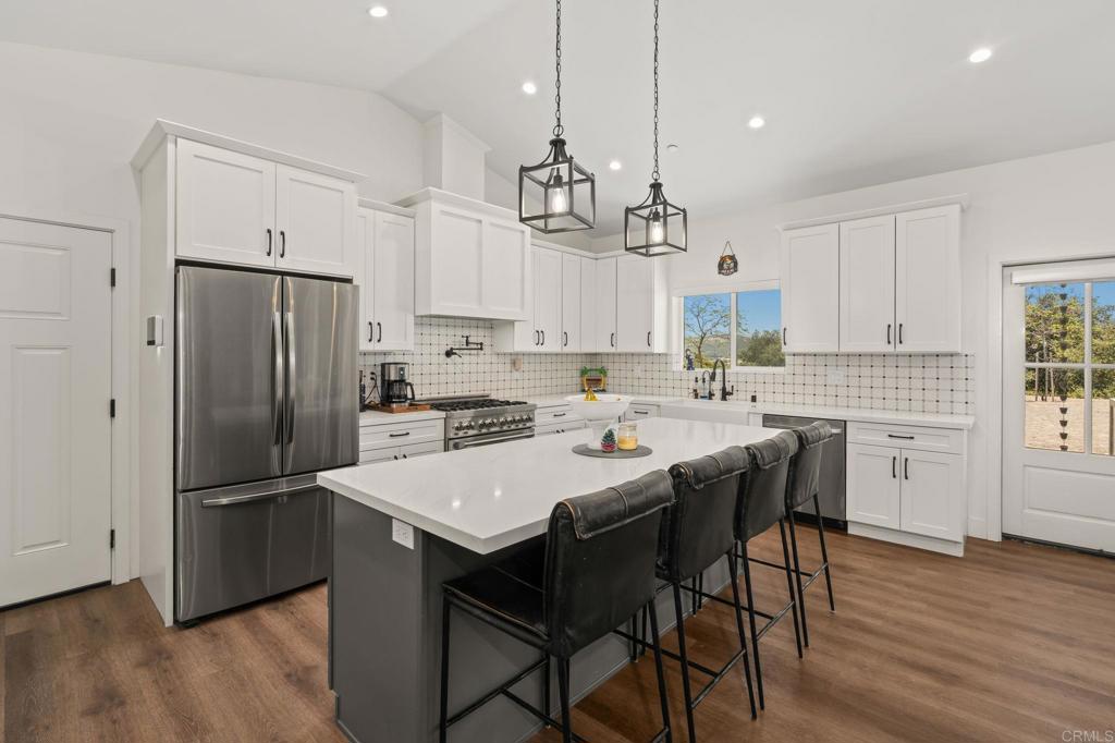 15663 Mathew Road Valley Center, CA 92082 - Photo 12 of 54 a kitchen with kitchen island a refrigerator a stove a sink and a refrigerator