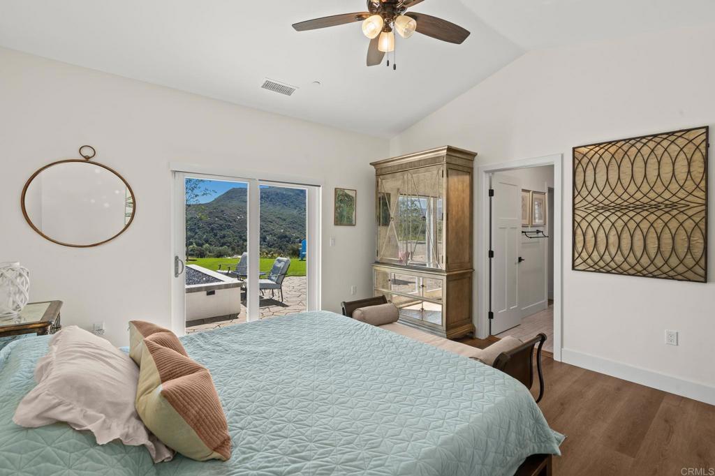 15663 Mathew Road Valley Center, CA 92082 - Photo 30 of 54 a bedroom with a bed a mirror and lamp