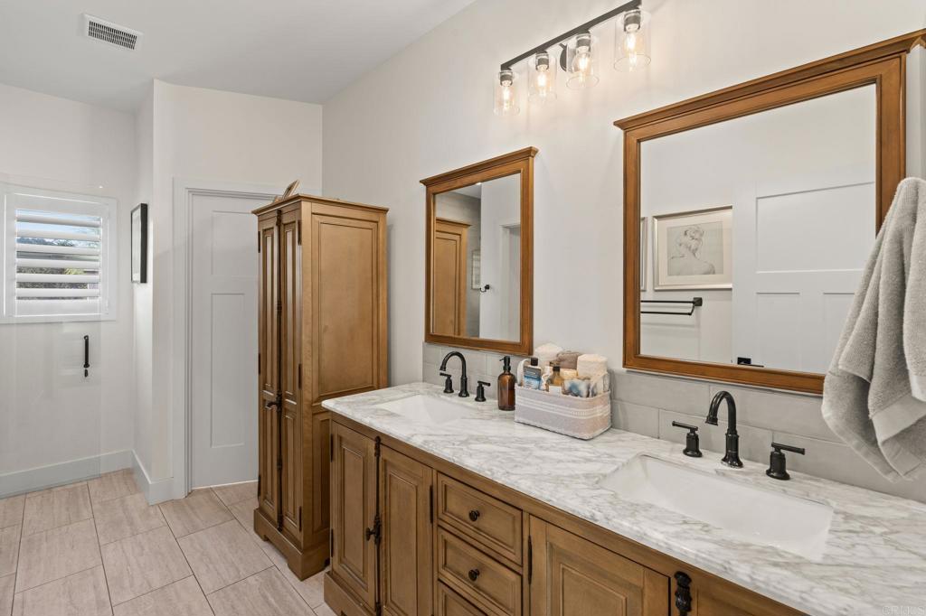 15663 Mathew Road Valley Center, CA 92082 - Photo 32 of 54 a bathroom with double vanity and a mirror