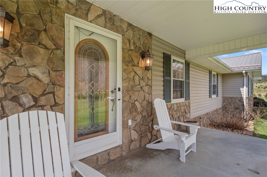 883 Bald Mountain Road West Jefferson, NC 28694 - Photo 43 of 47 a view of a door with a bench and chair