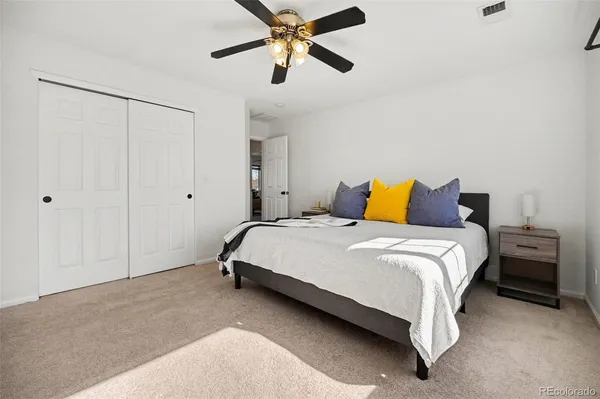 a bedroom with a bed and a ceiling fan