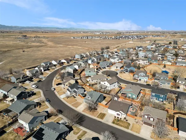 an aerial view of ocean and residential houses with outdoor space
