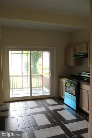 a view of kitchen with stove and refrigerator