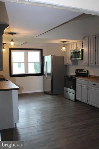 a kitchen with stainless steel appliances kitchen island granite countertop a stove a sink and a refrigerator