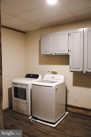 a utility room with wooden floor washer and dryer