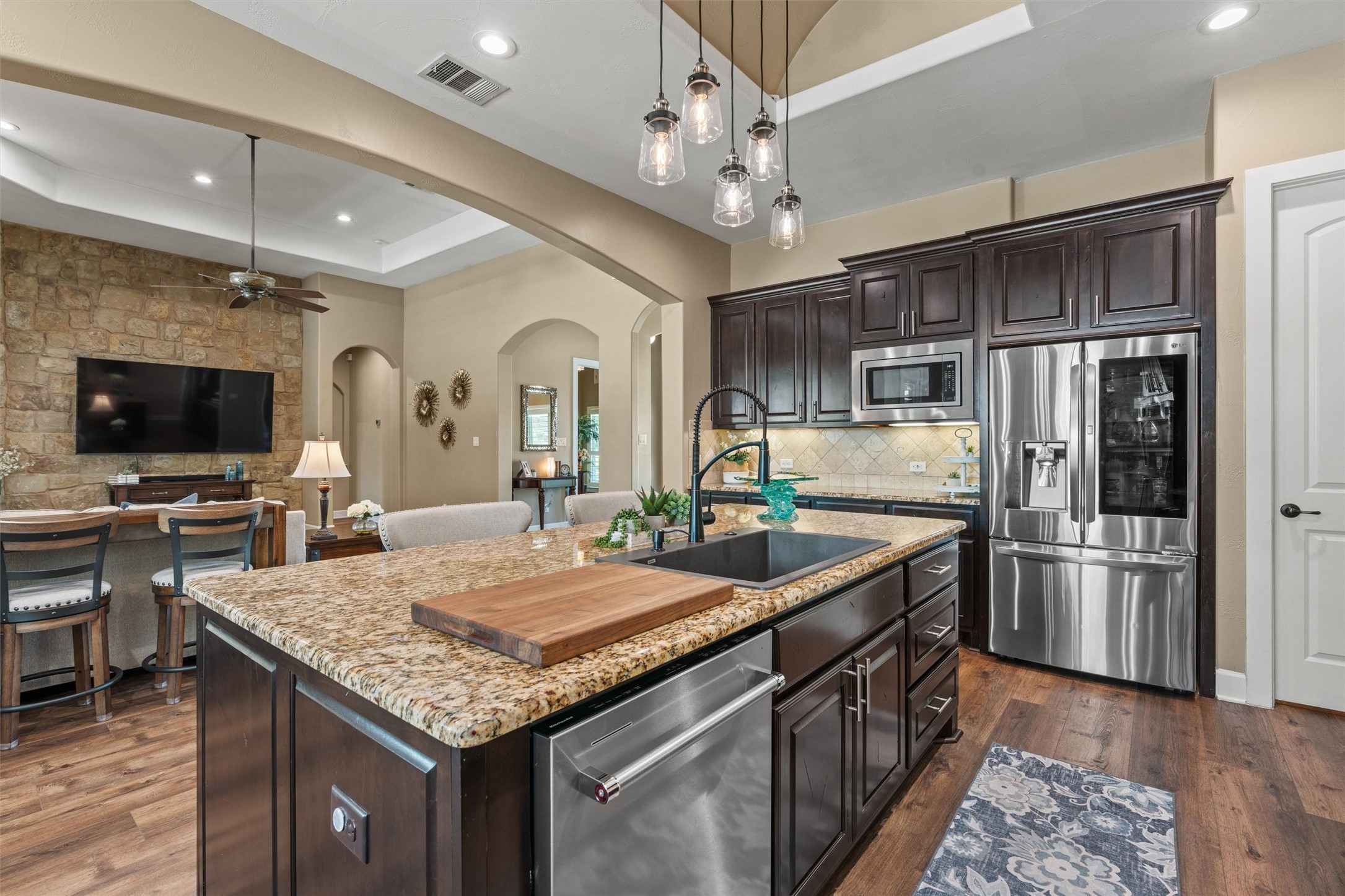104 Adobe Cove Georgetown, TX 78633 - Photo 10 of 40 An inviting open-concept kitchen features a large island with granite countertops and modern stainless steel appliances.