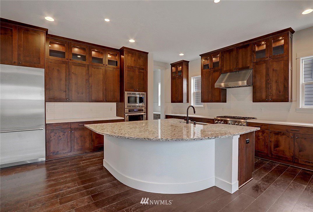 21714 35th Avenue Southeast, Unit 22 Bothell, WA 98021 - Photo 2 of 14 a large kitchen with stainless steel appliances granite countertop a sink and a stove