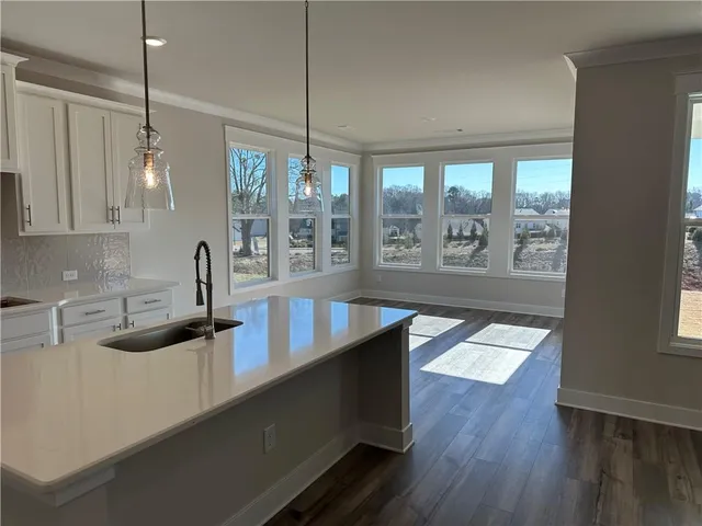 an empty room with windows and ceiling fan