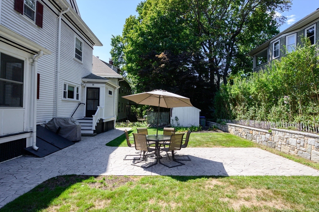 16 Beaumont Street Boston, MA 02124 - Photo 34 of 41 a view of a backyard with table and chairs under an umbrella