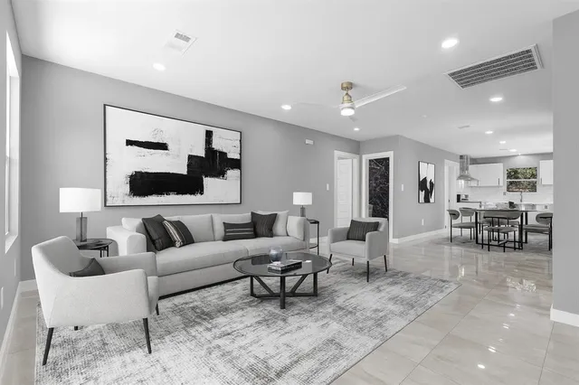 a living room with furniture and a dining table with wooden floor