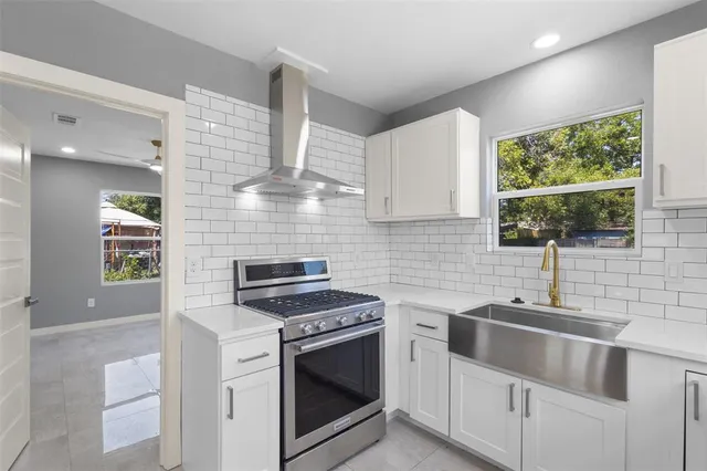 a kitchen with granite countertop a sink stainless steel appliances and cabinets