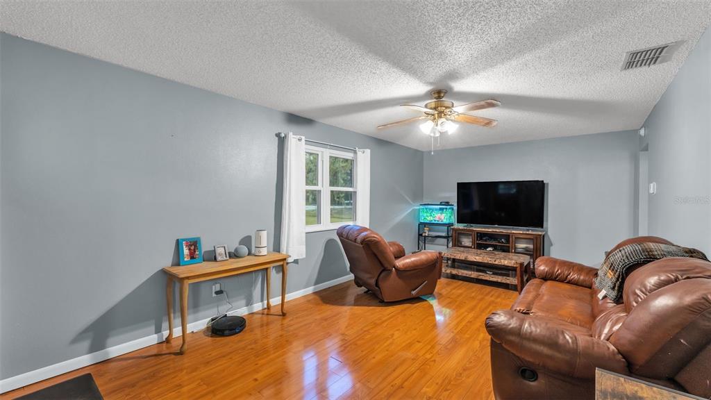 13700 Pine Meadow Road Kathleen, FL 33849 - Photo 15 of 39 a living room with furniture and a flat screen tv