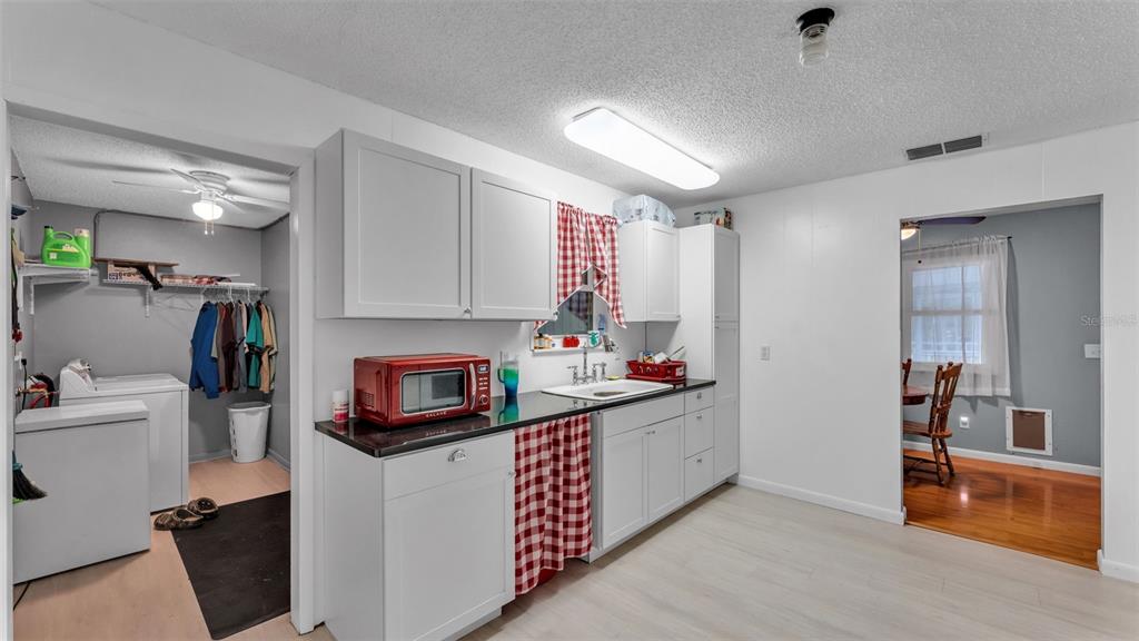 13700 Pine Meadow Road Kathleen, FL 33849 - Photo 21 of 39 a kitchen with sink refrigerator and microwave