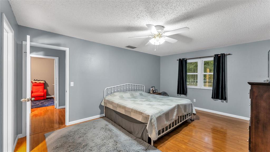 13700 Pine Meadow Road Kathleen, FL 33849 - Photo 24 of 39 a spacious bedroom with a bed and a chandelier