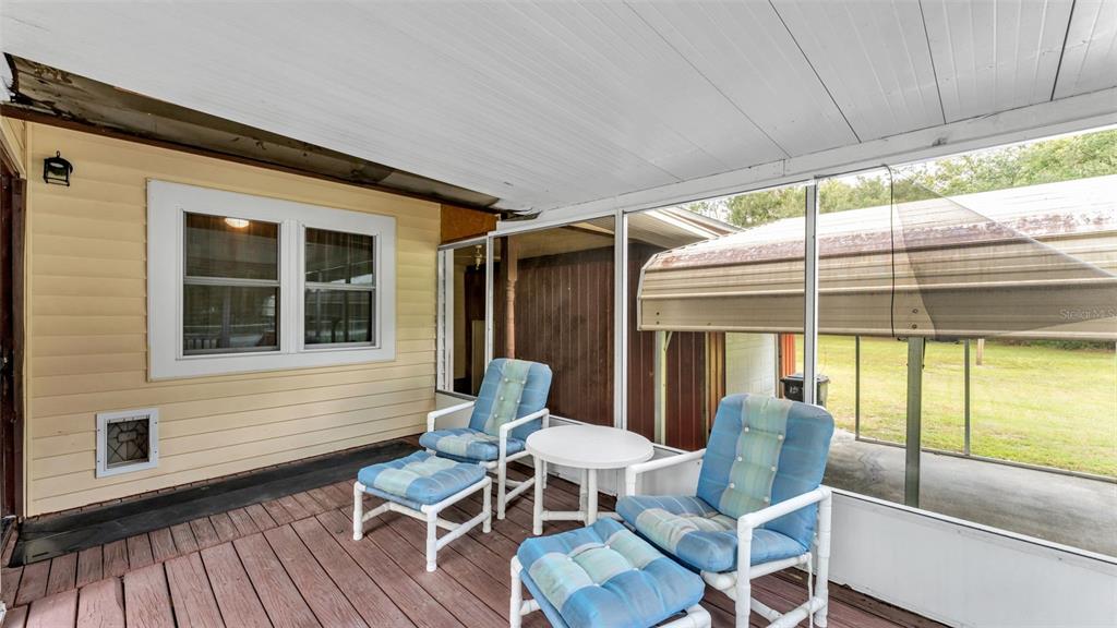 13700 Pine Meadow Road Kathleen, FL 33849 - Photo 10 of 39 a view of a patio with table and chairs and wooden floor