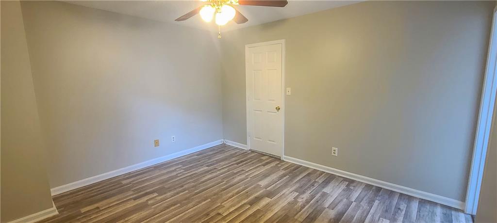 2120 Fairways Court Kennesaw, GA 30144 - Photo 15 of 20 an empty room with a chandelier fan and wooden floor
