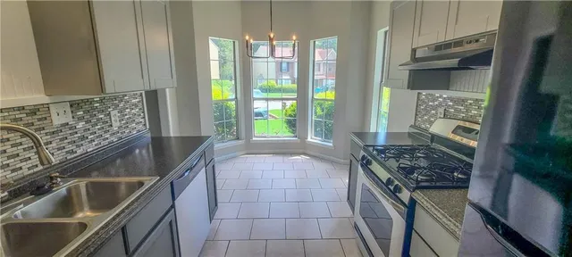 a kitchen with granite countertop a stove and a sink