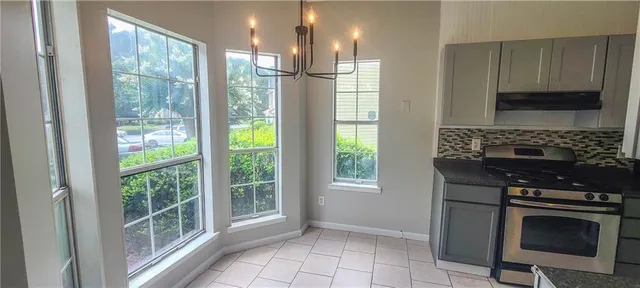 a kitchen with windows a sink and a stove