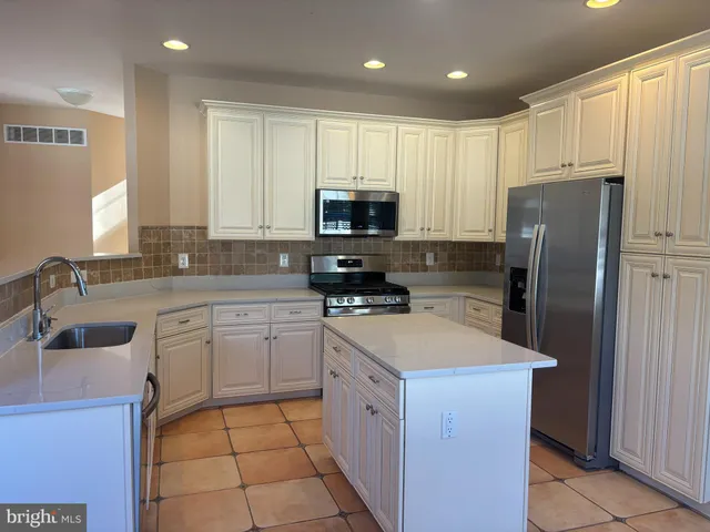 a kitchen with a sink a microwave a refrigerator and cabinets