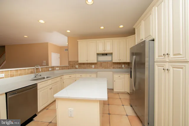 a kitchen with a refrigerator sink and cabinets