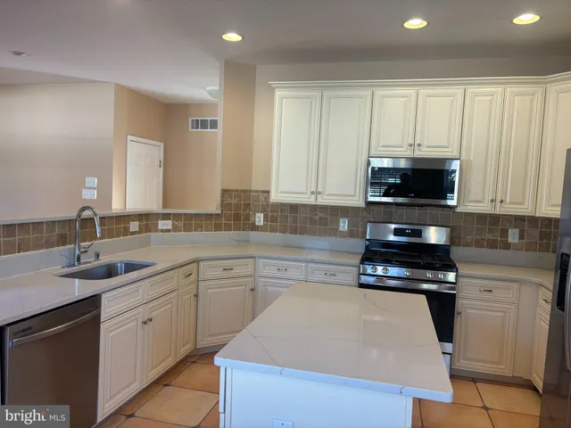 a kitchen with a sink a stove and cabinets