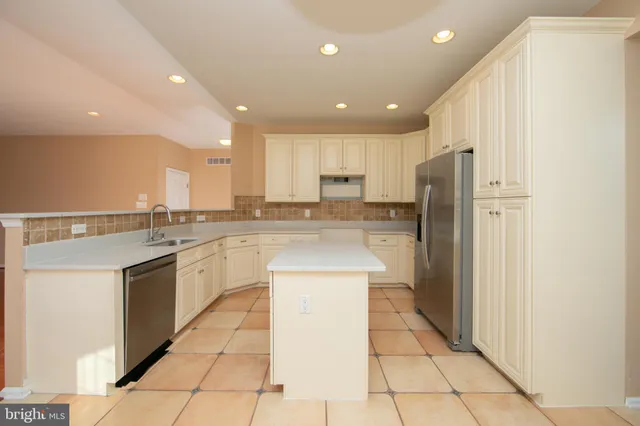 a kitchen with stainless steel appliances granite countertop a refrigerator a sink and a stove