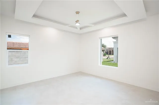 an empty room with windows and ceiling fan