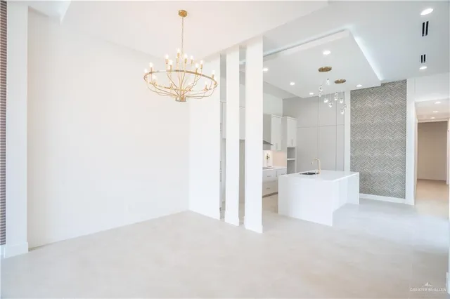 a view of an empty room and kitchen view