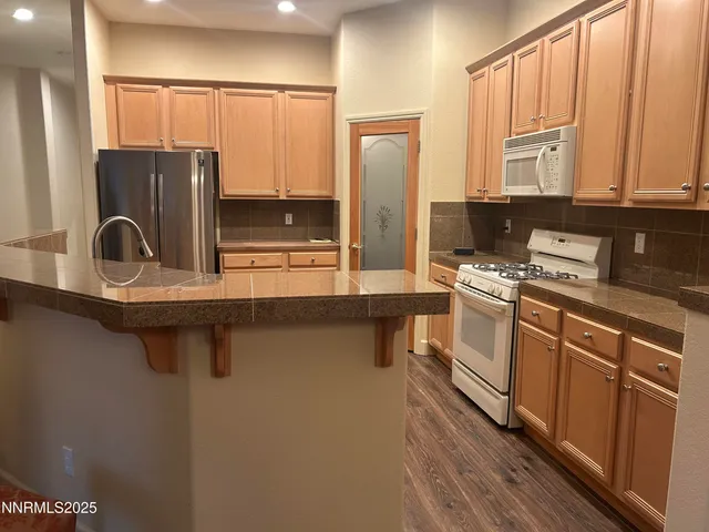 a kitchen with a refrigerator sink and cabinets
