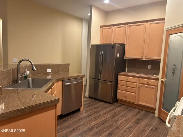 a kitchen with stainless steel appliances granite countertop a sink refrigerator and cabinets