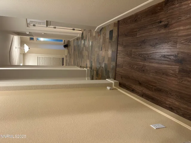 a view of an empty room with furniture and a window