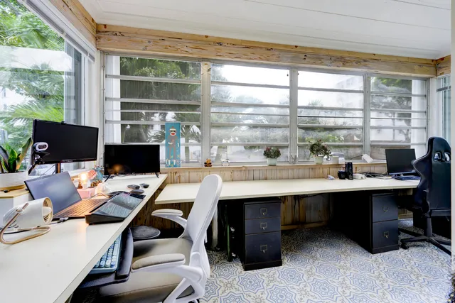 a view of a workspace with furniture and a window