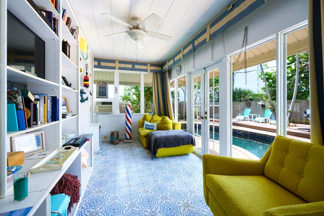 a living room with furniture a flat screen tv and a floor to ceiling window