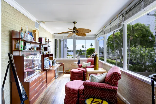 a living room with furniture a bookshelf and a large window