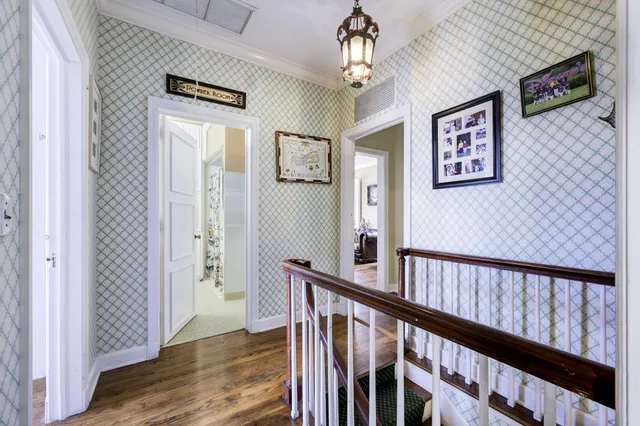 a view of a hallway with wooden floor and staircase