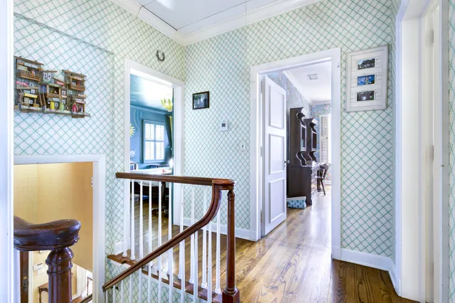 a view of a hallway with wooden floor and windows