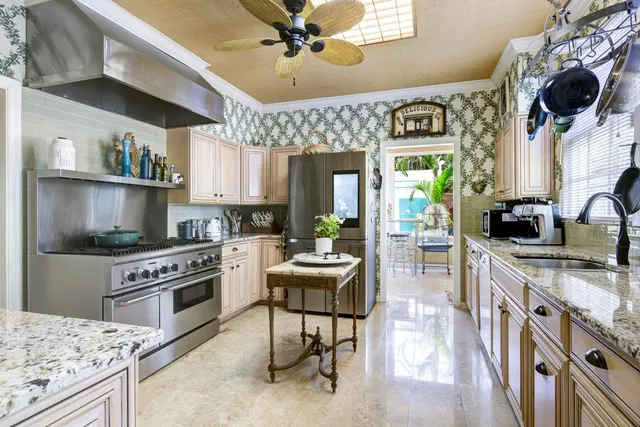 a kitchen with stainless steel appliances granite countertop a stove top oven a sink a dining table and chairs with wooden floor