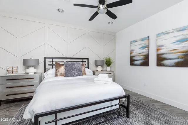 a bedroom with a large bed and a chandelier